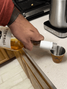 a person is pouring screwball into a measuring cup