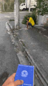 a man in a yellow shirt is sitting on a curb next to a truck that says pete on it