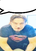 a man wearing a superman t-shirt is sitting on a chair .