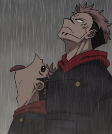 a man in a black jacket and red hoodie stands in the rain looking up