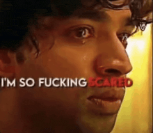 a close up of a man 's face with the words `` i 'm so fucking scared '' behind him .