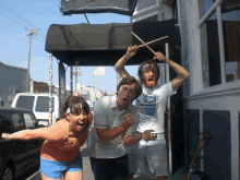 a group of people are posing for a picture in front of a building that has a sign on it that says ' no parking '