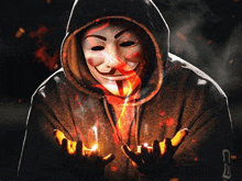 a man wearing a hooded sweatshirt and a anonymous mask is holding something in his hands .