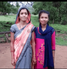 two women standing next to each other with one wearing a pink top