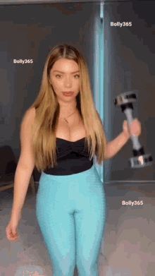 a woman is holding a dumbbell in her hand .