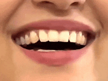 a close up of a woman 's mouth with white teeth and red lips .