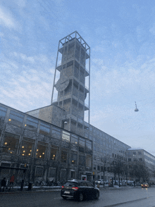 a building with a clock tower on top of it and a car in front of it