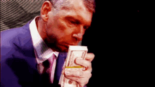 a man in a suit and tie is holding a stack of twenty dollar bills