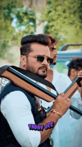a man holding a gun with yaday jee written in the corner