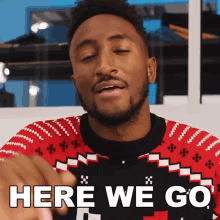 a man wearing a red sweater says here we go