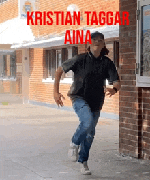 a young man is running in front of a brick building with the name kristian taggar aina written in red