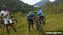 a group of cyclists are standing on a grassy hill and one of them has the number 10 on his shirt