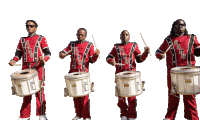 a group of men in red uniforms are playing drums