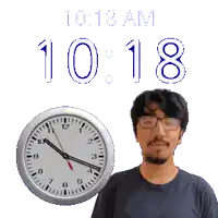 a man wearing glasses stands next to a clock that says 10:18 am