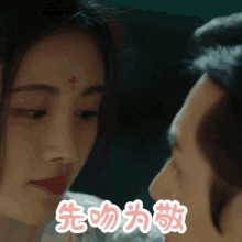 a close up of a man and woman kissing with chinese writing behind them