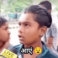 a young boy is talking into a microphone in a foreign language .