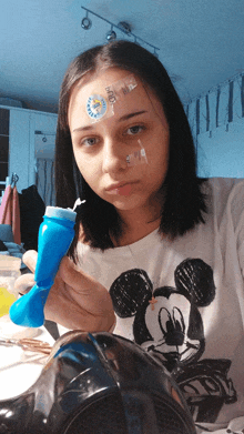 a girl with a bandage on her forehead holds a mickey mouse toy