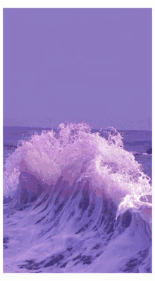 a purple wave is breaking on the beach with a purple sky in the background