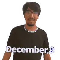 a man wearing glasses and a black shirt that says december 9 on it