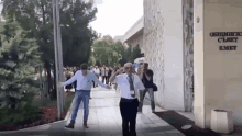 two men are walking in front of a building that says kmt