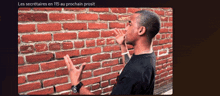 a man standing in front of a red brick wall with the words les secretaries en 115 au prochain prosit below him