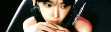 a close up of a woman holding a knife in her hand .