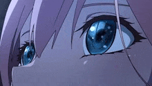 a close up of a person 's blue eyes with purple hair .