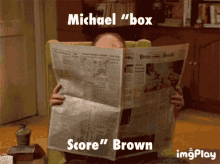 a man is reading a newspaper with the words michael " box " and score " brown "