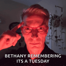 a man wearing red glasses with the words bethany remembering it 's a tuesday below him