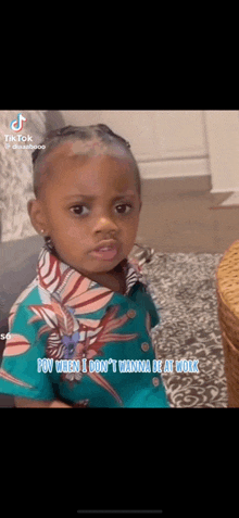 a little girl is sitting on a couch in a living room wearing a green shirt .