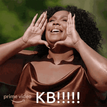 a woman in a brown dress is making a heart with her hands in front of her face and the words prime video kb !!! below her