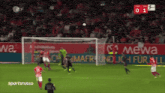 a soccer game is being played in front of a banner for mewa