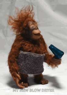 a stuffed monkey holding a blow dryer with the caption " my new blow dryer " below it
