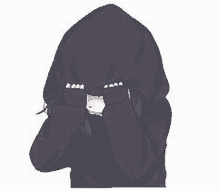 a girl is wearing a hoodie and covering her face with her hands .