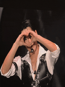 a man is making a heart shape with his hands