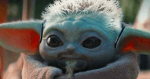 a close up of a baby yoda with a beard and sunglasses on .