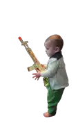 a baby is holding a toy rifle with a red tip