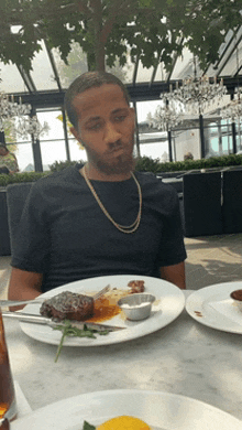 a man is sitting at a table with a plate of food on it