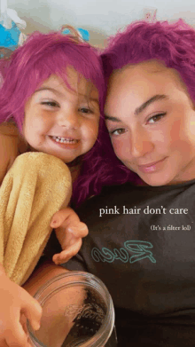 a woman with purple hair is holding a little girl