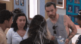 a group of people standing around a man holding a bowl