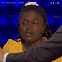 a woman in a yellow dress is being interviewed by a man in a suit and the caption says family feud canada