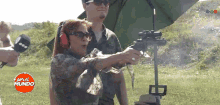 a man and a woman are standing in a field with a sign that says " pere el mundo "