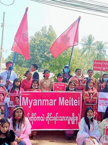 a group of people are holding signs that say myanmar meitei