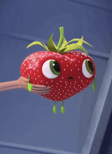 a person is holding a strawberry with green eyes