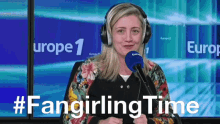 a woman wearing headphones stands in front of a microphone with the hashtag #fangirlingtime