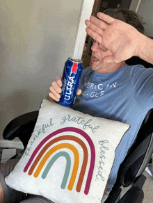 a man sitting in a chair holding a can of miller lite beer