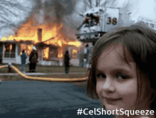 a girl stands in front of a burning house with #celshortsqueeze written below her