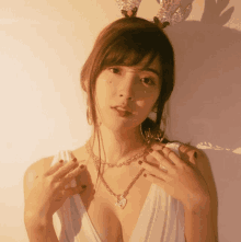 a woman wearing a reindeer headband and a white dress