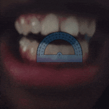 a ruler is being used to measure a person 's teeth in degrees