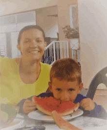 a woman and a child are eating watermelon together